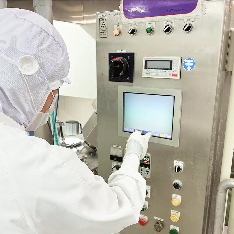 防塵衣を着用して工場内で作業する従業員